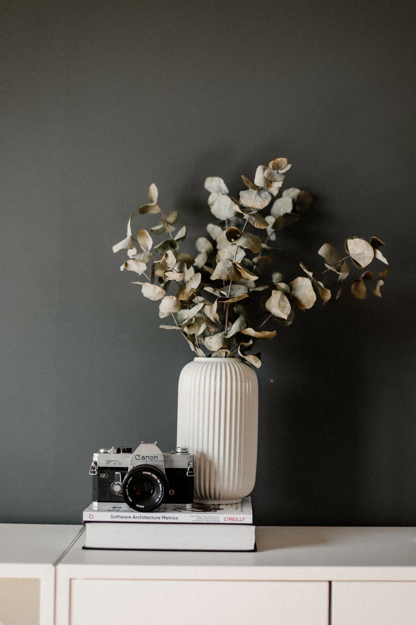 Film camera beside a vase of flowers