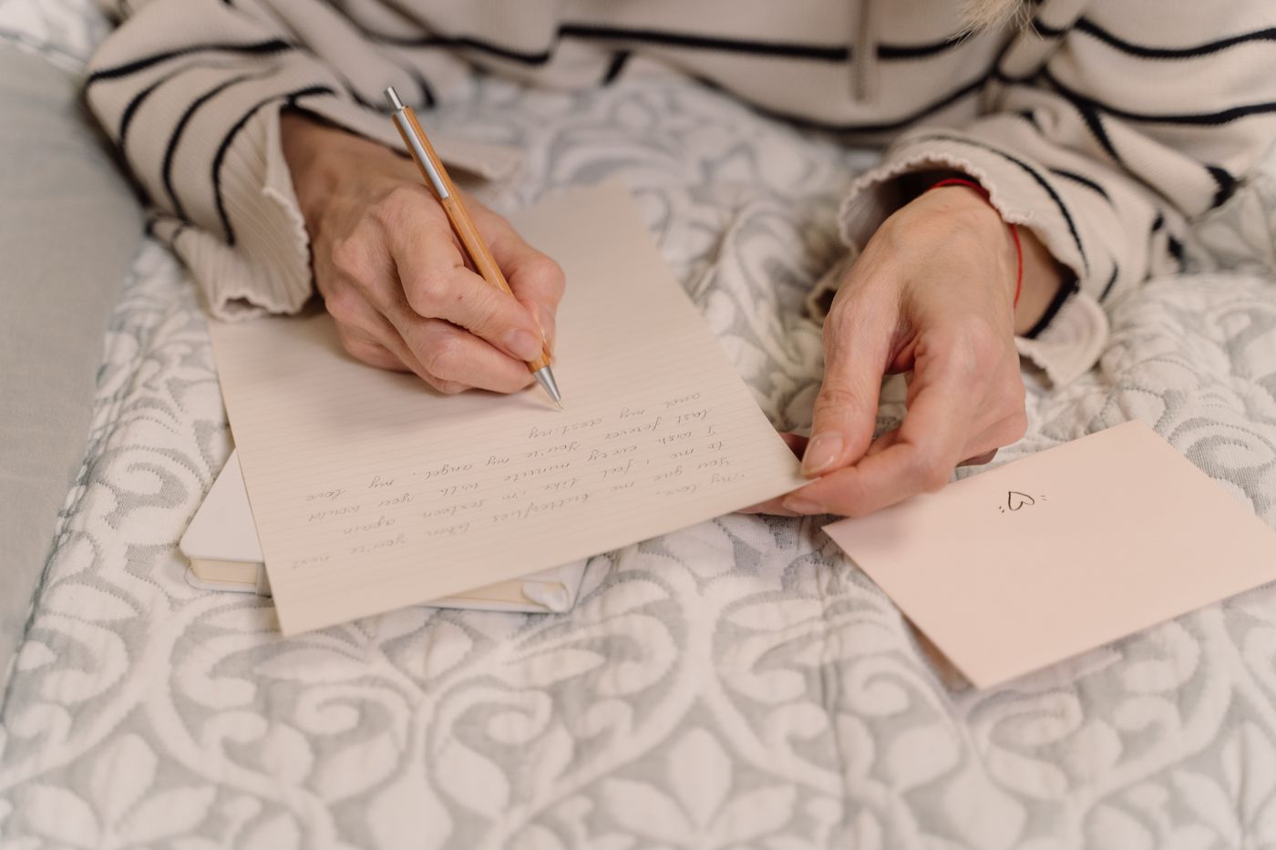 A person writing a letter at a table
