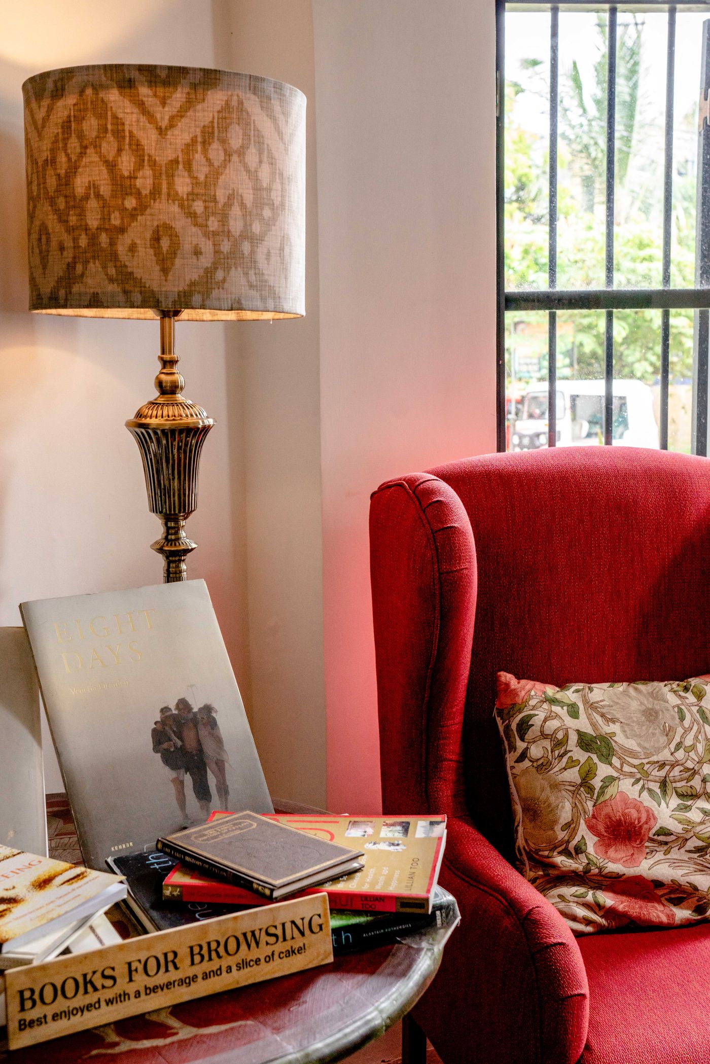 Red armchair with a lamp and books in a reading corner